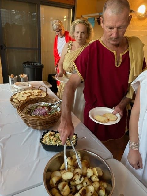 A Man In A Red Shirt Is Holding A Plate Of Food — Tru Blu Catering In Coffs Harbour, NSW