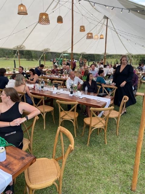 A Group Of People Are Sitting At Tables Under A Tent — Tru Blu Catering In Wauchope, NSW