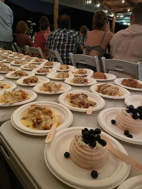 Many Plates Of Food On A Table With People Sitting In The Background — Tru Blu Catering In Taree, NSW