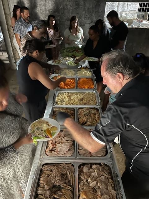 A Group Of People Are Getting Food From A Buffet Line — Tru Blu Catering In Port Macquarie, NSW