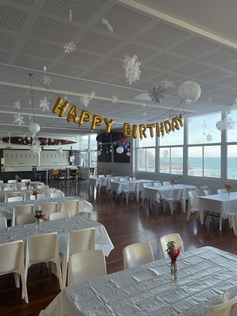 A Large Room With Tables And Chairs And A Banner That Says Happy Birthday — Tru Blu Catering In Port Macquarie, NSW