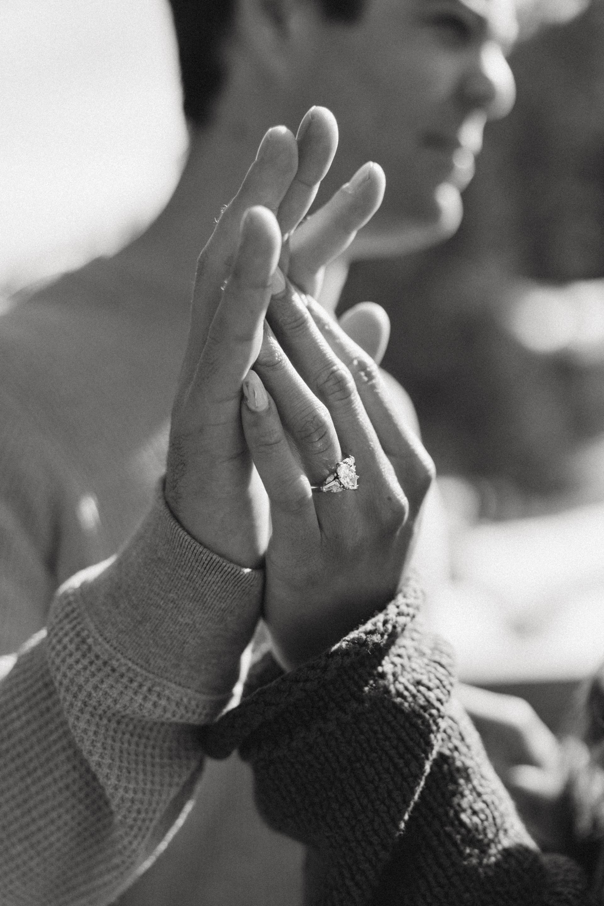 Two hands pressed together in a high-five, with a blurred person in the background.
