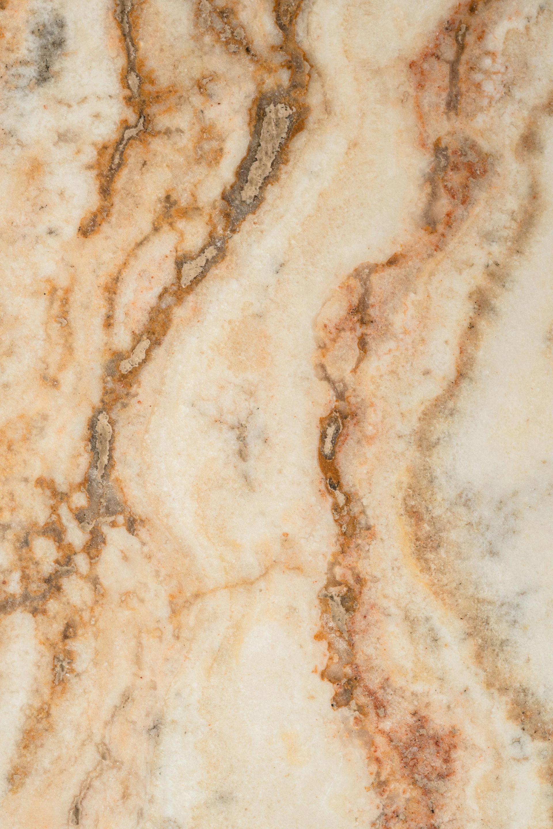 Cream-colored marble with brown and reddish-brown veining, a swirling pattern.