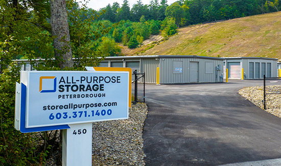 Sign for All-Purpose Storage in Peterborough. Storage units in background on a hill.