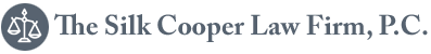 Logo for The Silk Cooper Law Firm, P.C. featuring a grey circular icon with a white scale of justice.