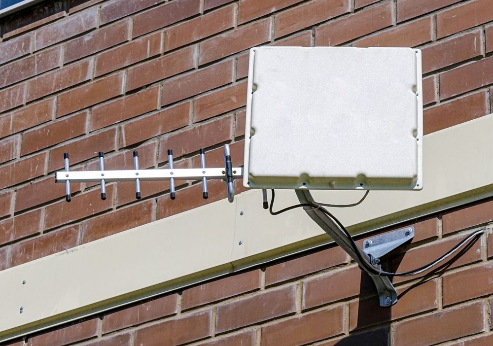 Antenna and White Box Mounted on Brick Wall — MATV Systems Australia Pty Ltd in Coffs Harbour, ACT