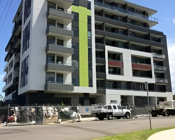 A Large Apartment Building with A Green Stripe on The Side — MATV Systems Australia in Mayfield, NSW