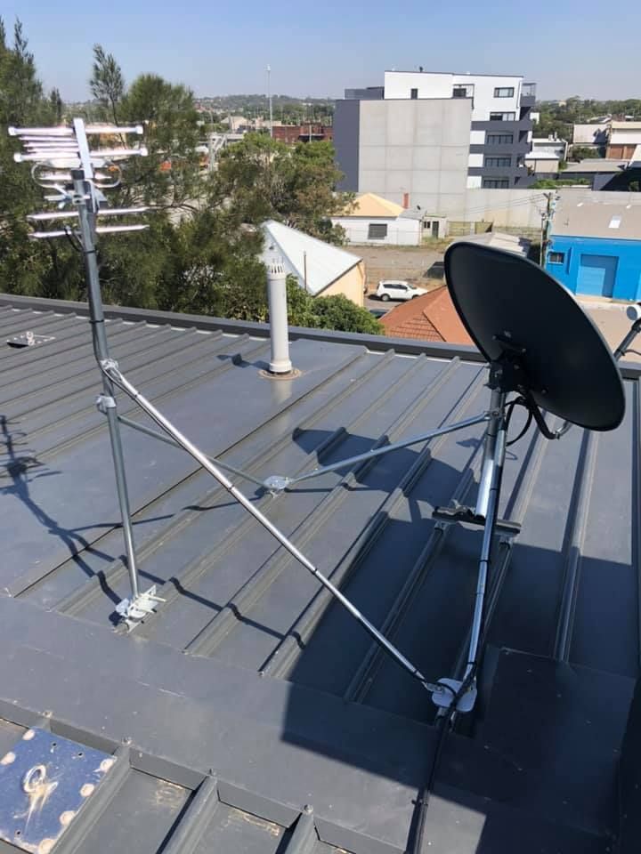 Rooftop With Satellite Dish and TV Antenna Above a Metal Roof — MATV Systems Australia Pty Ltd in Wickham, NSW