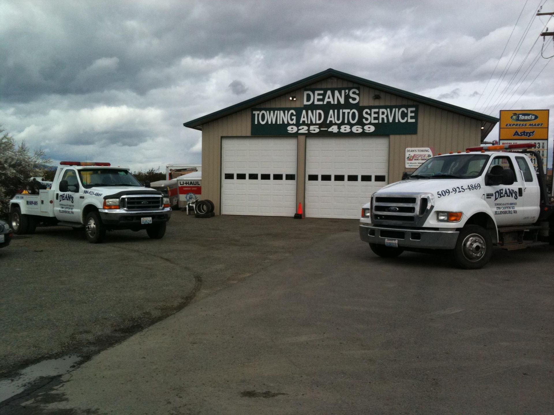 Two towing trucks are parked in front of dean 's towing and auto service