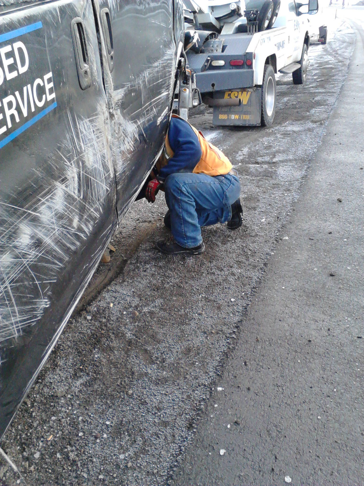 A man is working on the side of a truck that says used service.