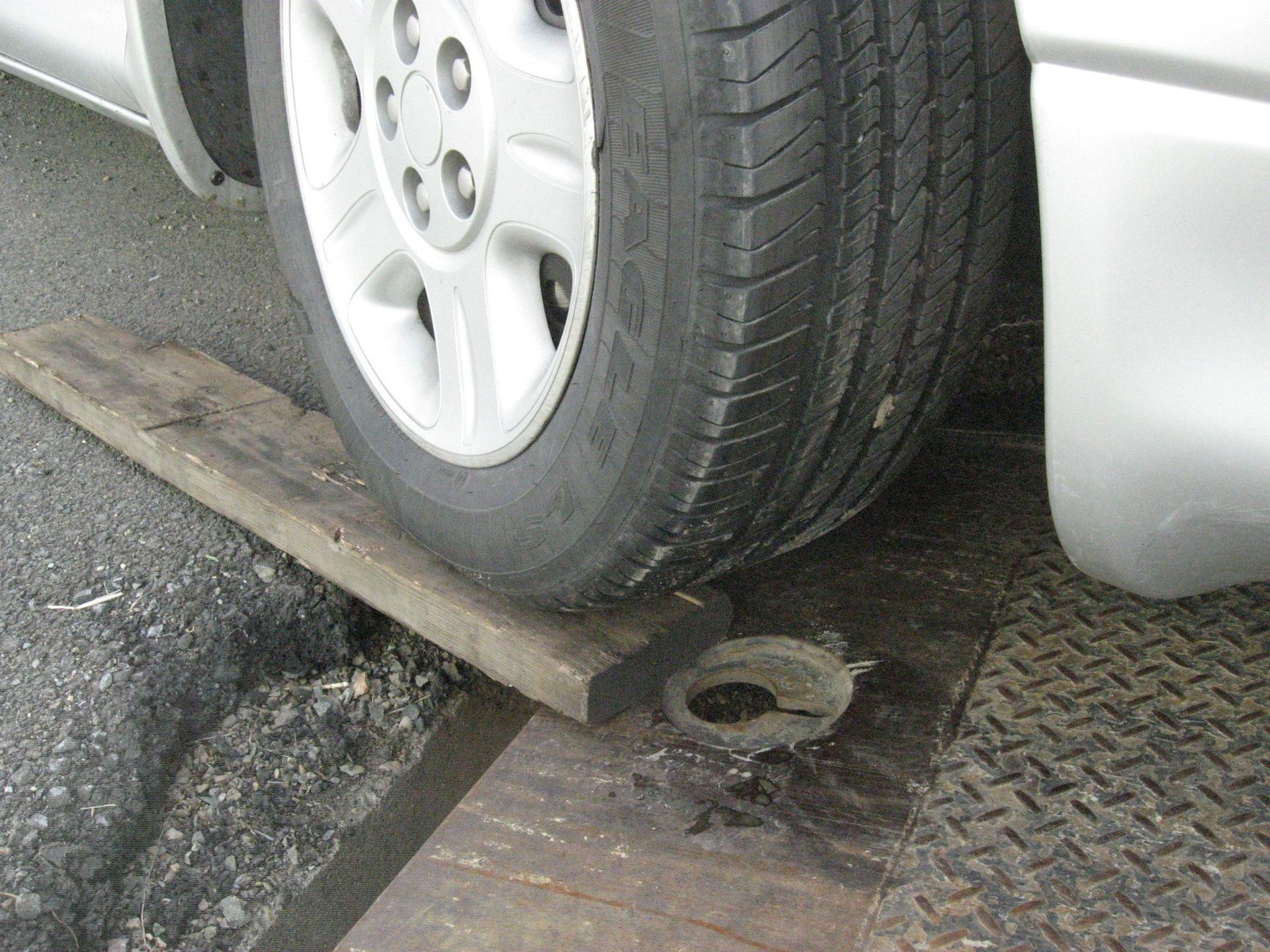 A close up of a car 's tire on a wooden ramp