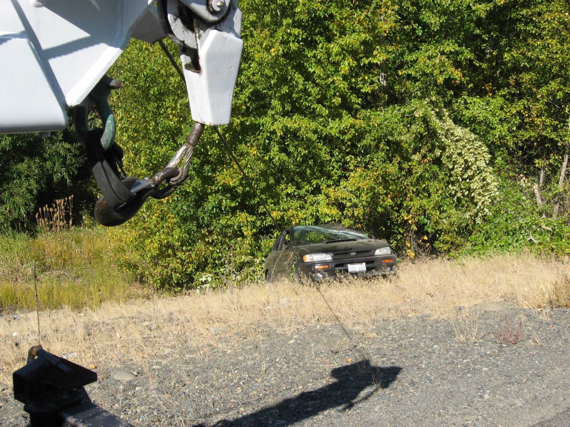 A black car is parked on the side of the road