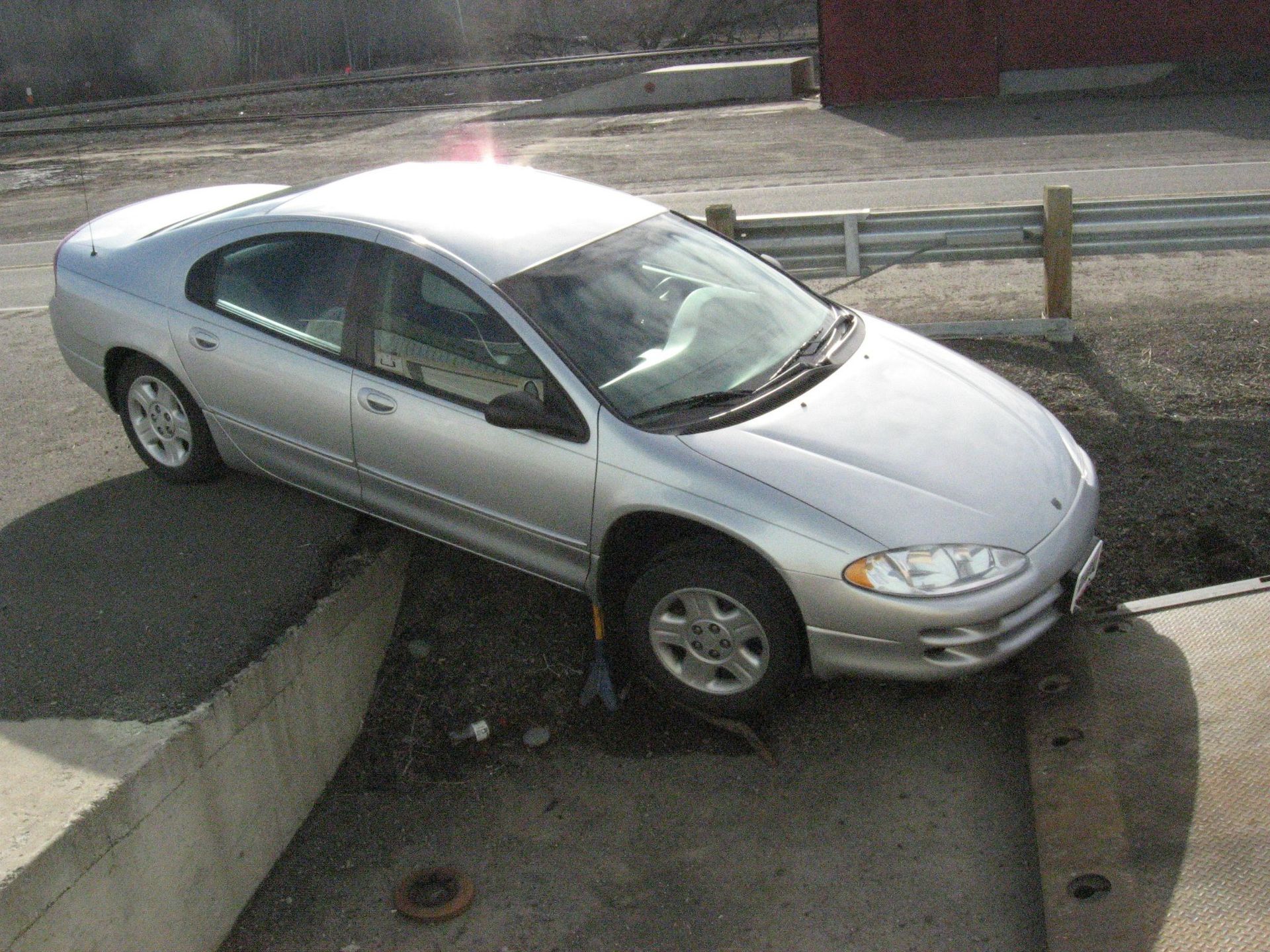 A silver car is parked on the side of the road