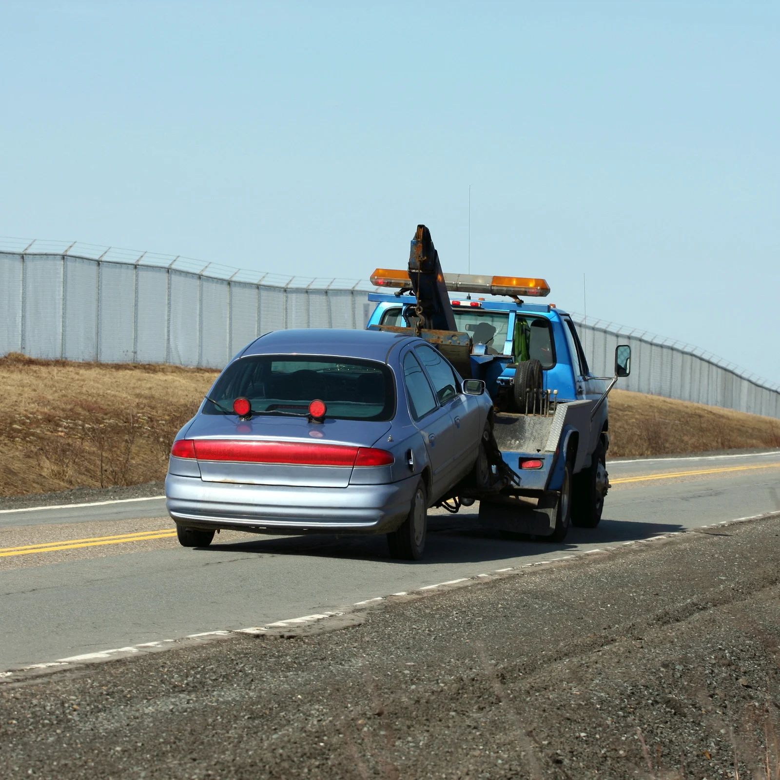 A car is being towed by a tow truck