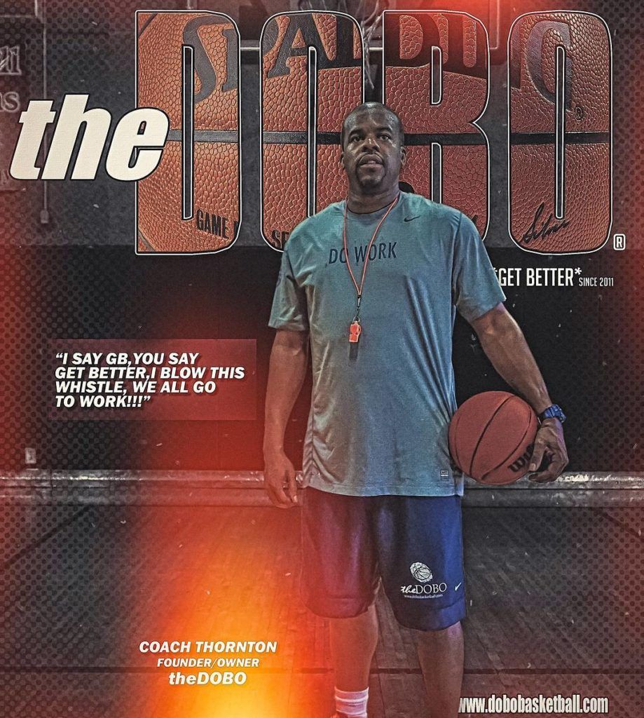 A man is holding a basketball in front of the word the