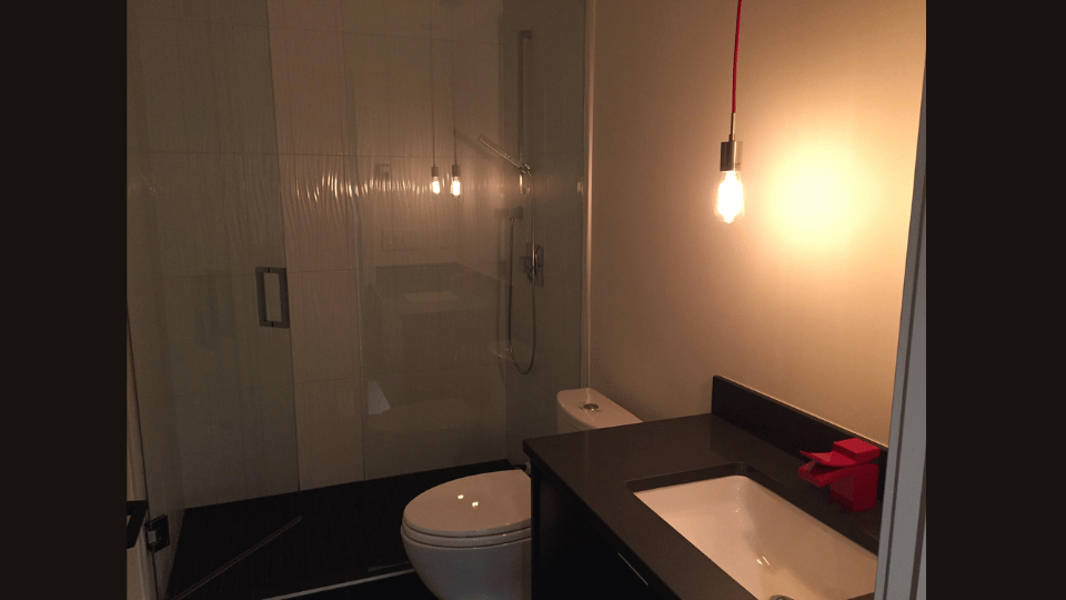 A bathroom with a toilet , sink and shower.