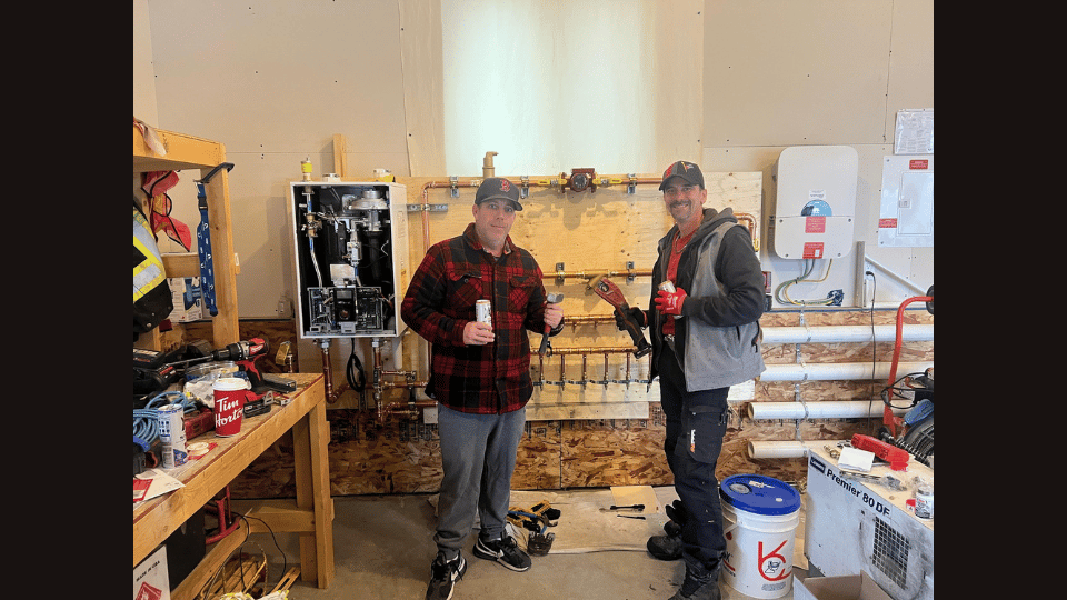 Two men are standing next to each other in a room.