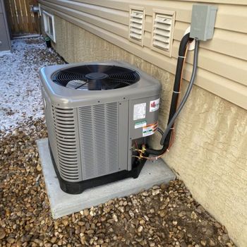 An air conditioner is attached to the side of a house