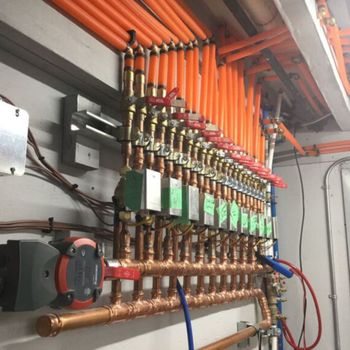 A bunch of copper pipes are hanging on a wall