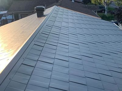 Un gros plan d'un toit avec une cheminée au-dessus.