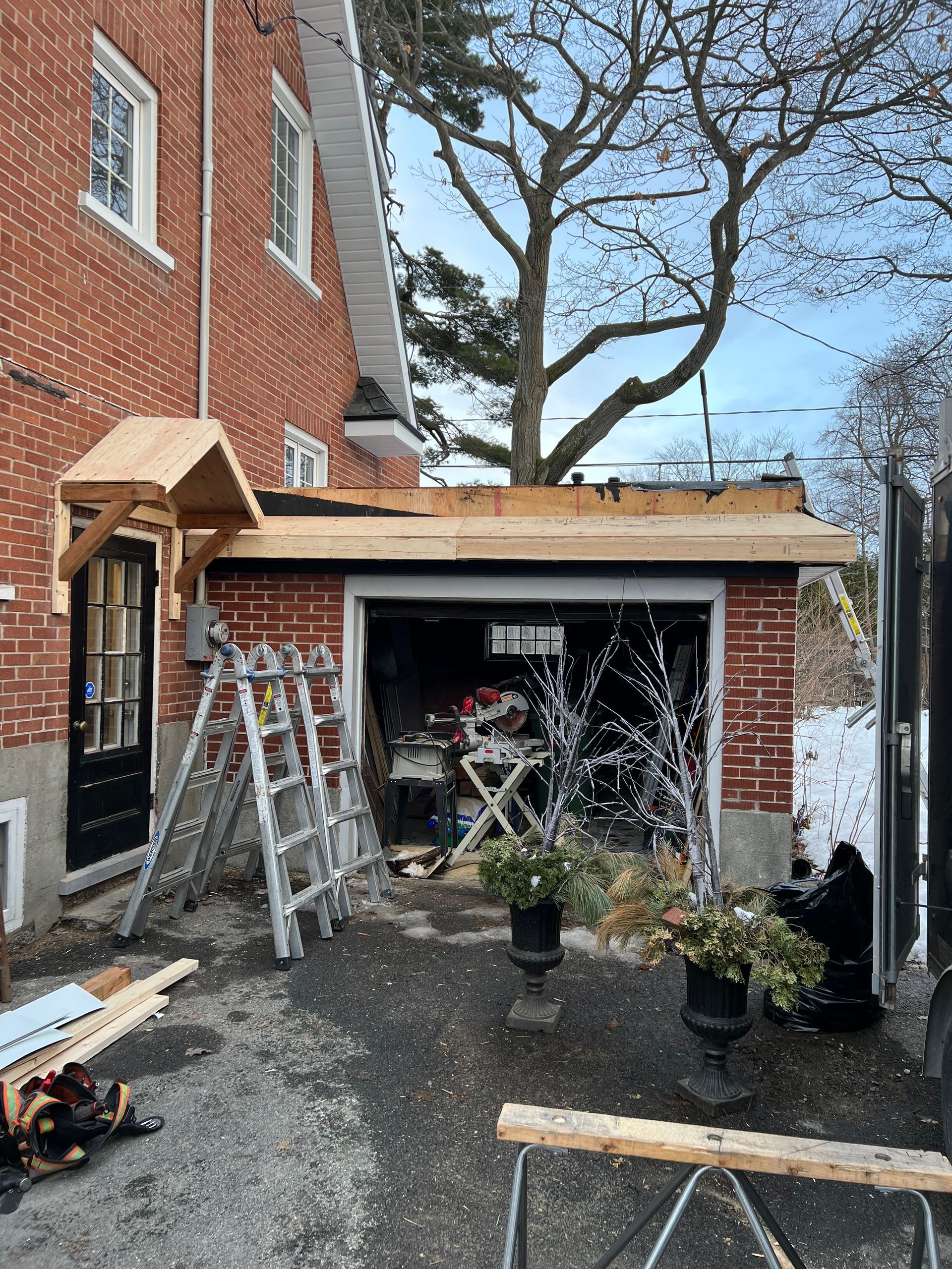 Un garage est en cours de rénovation avec un auvent en bois.
