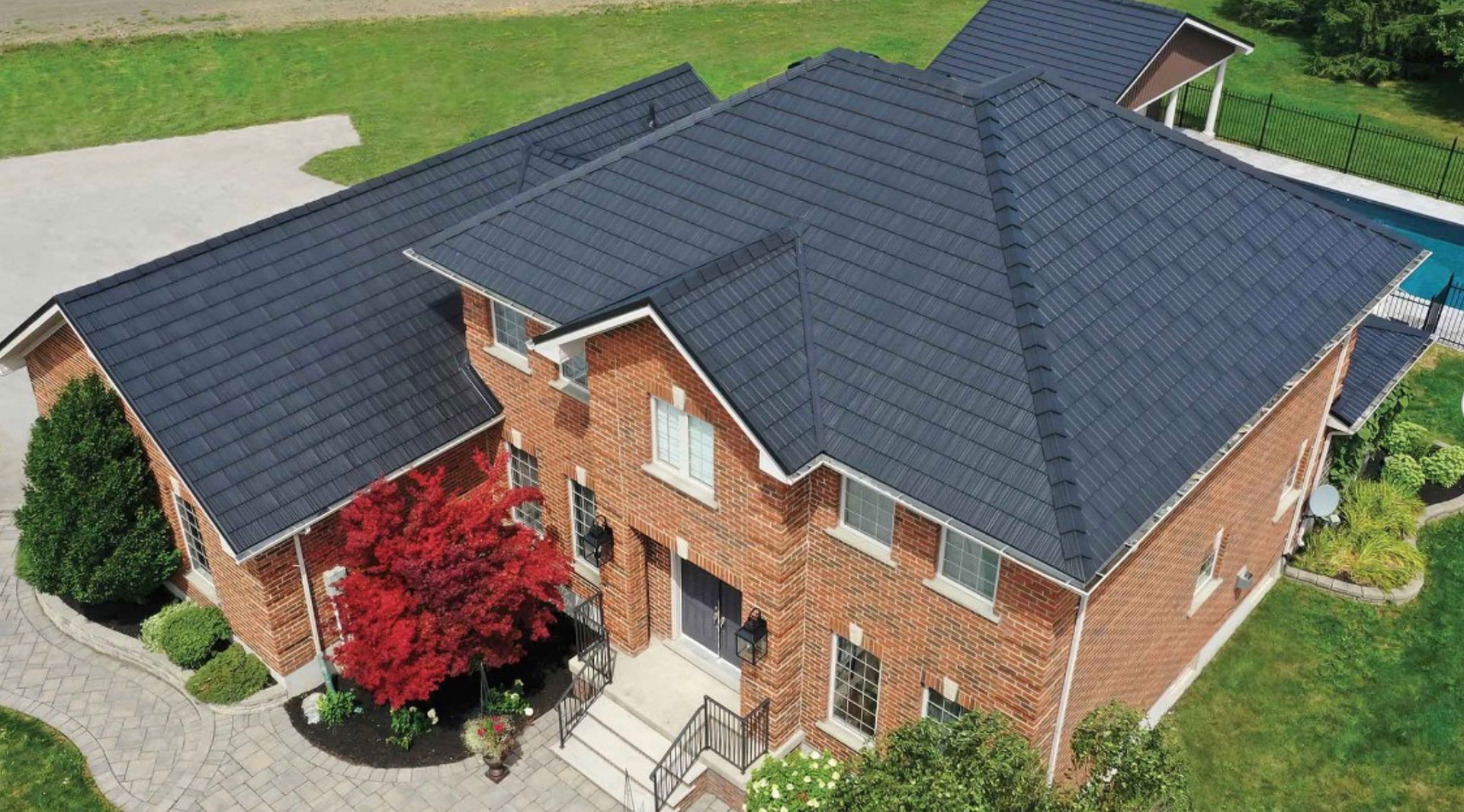 Une vue aérienne d'une grande maison en brique avec un toit noir