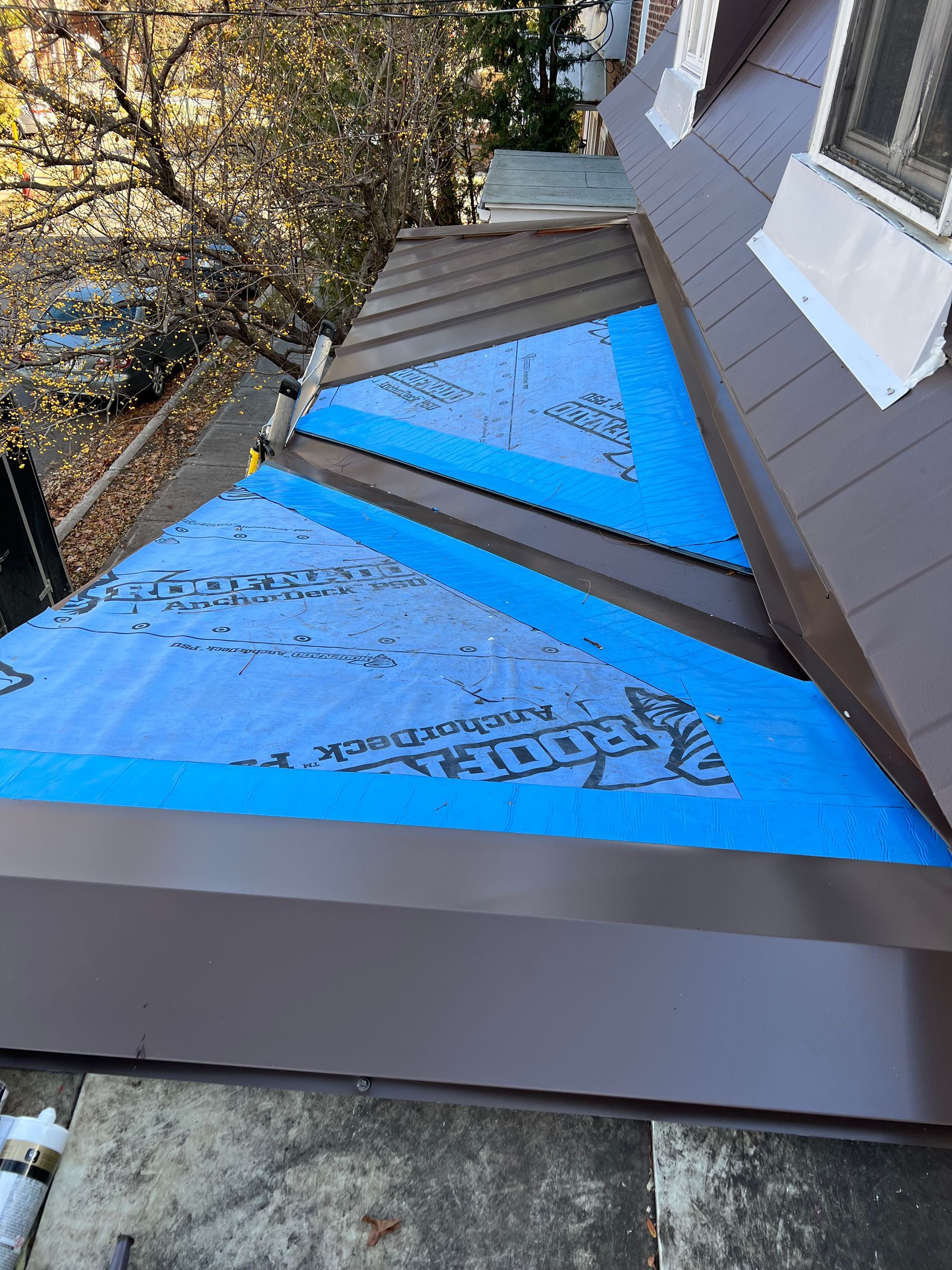 Une bâche bleue recouvre le toit d'une maison.