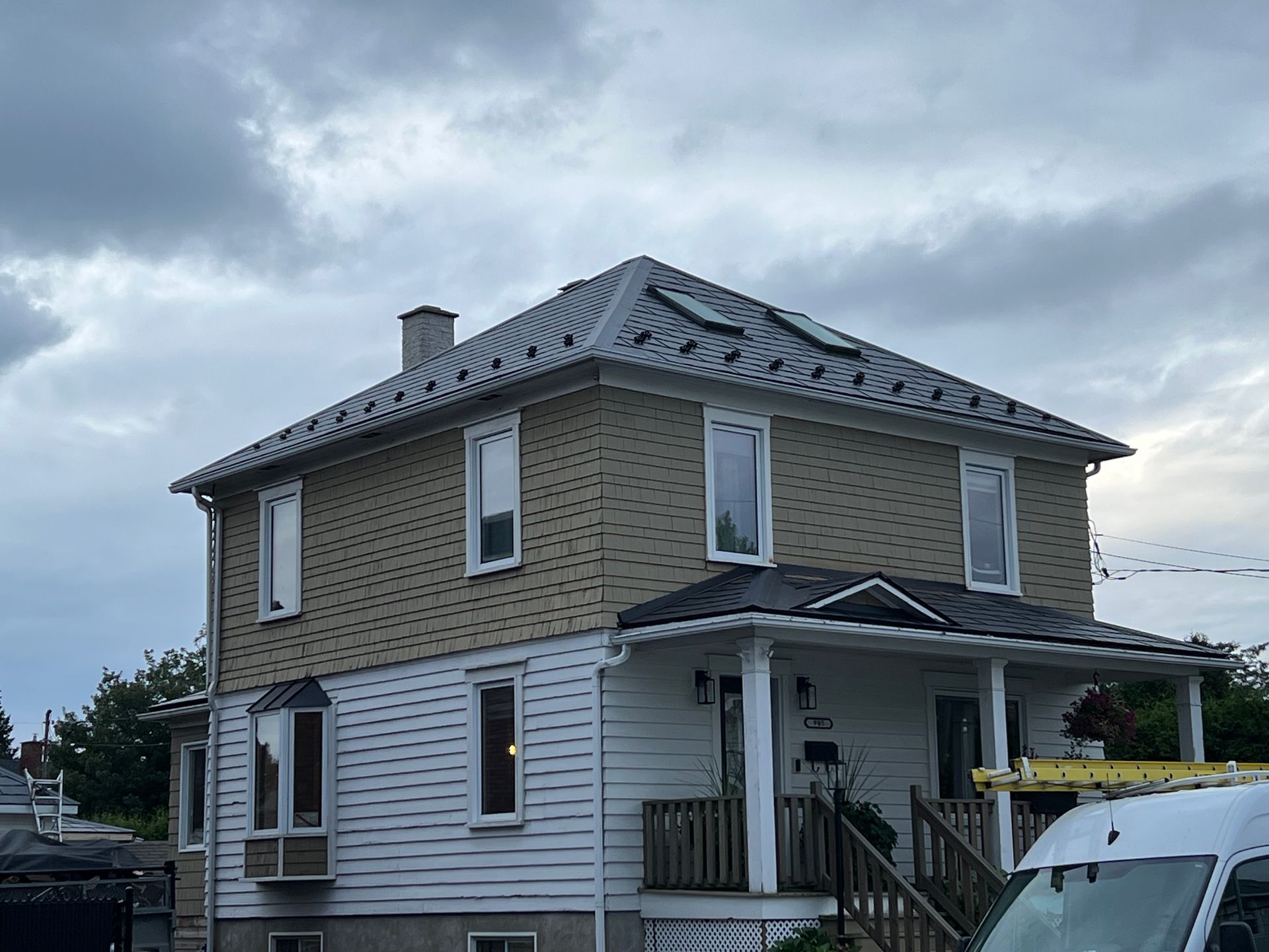 Une maison avec une camionnette blanche garée devant.