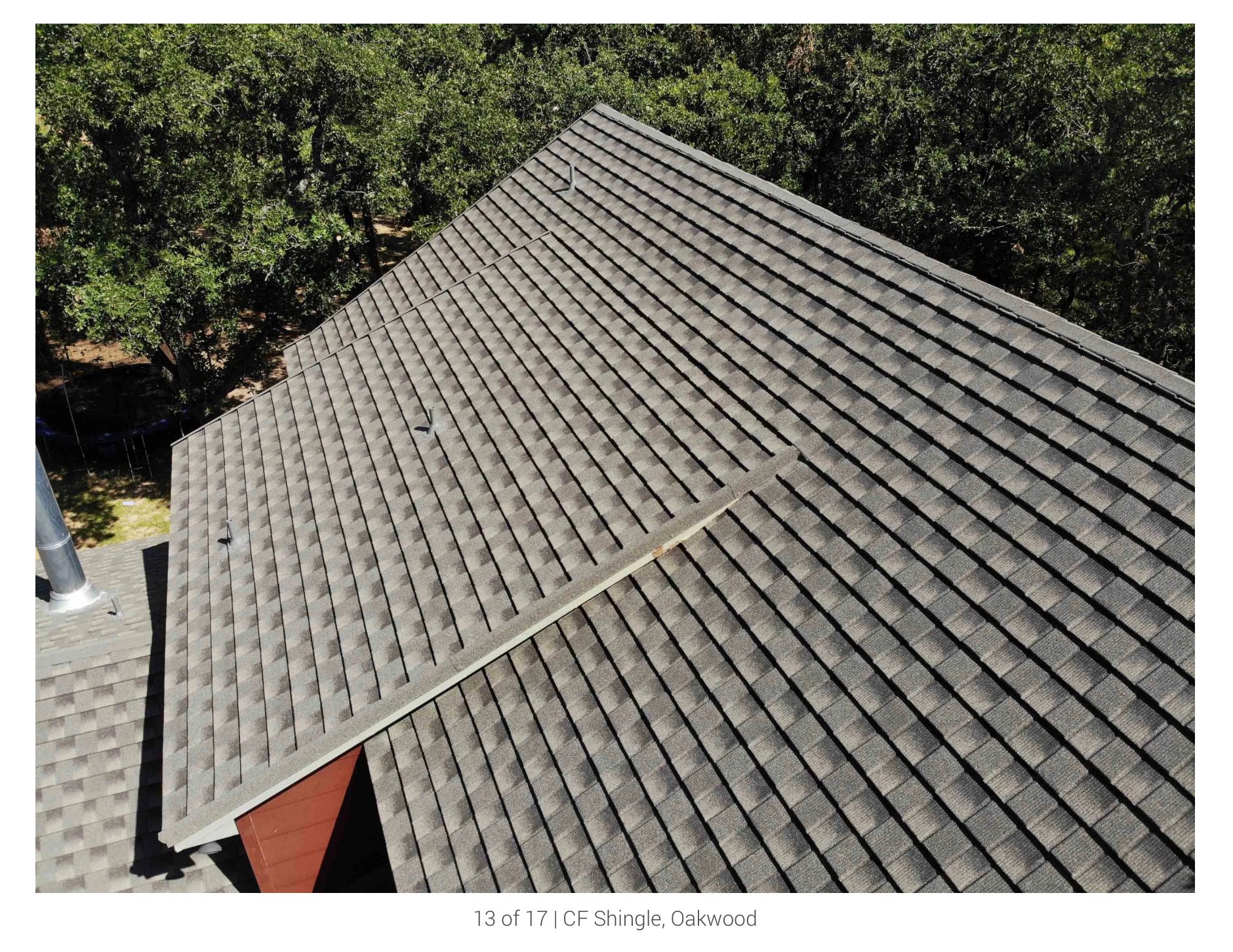 Une vue aérienne du toit d'une maison avec des arbres en arrière-plan.