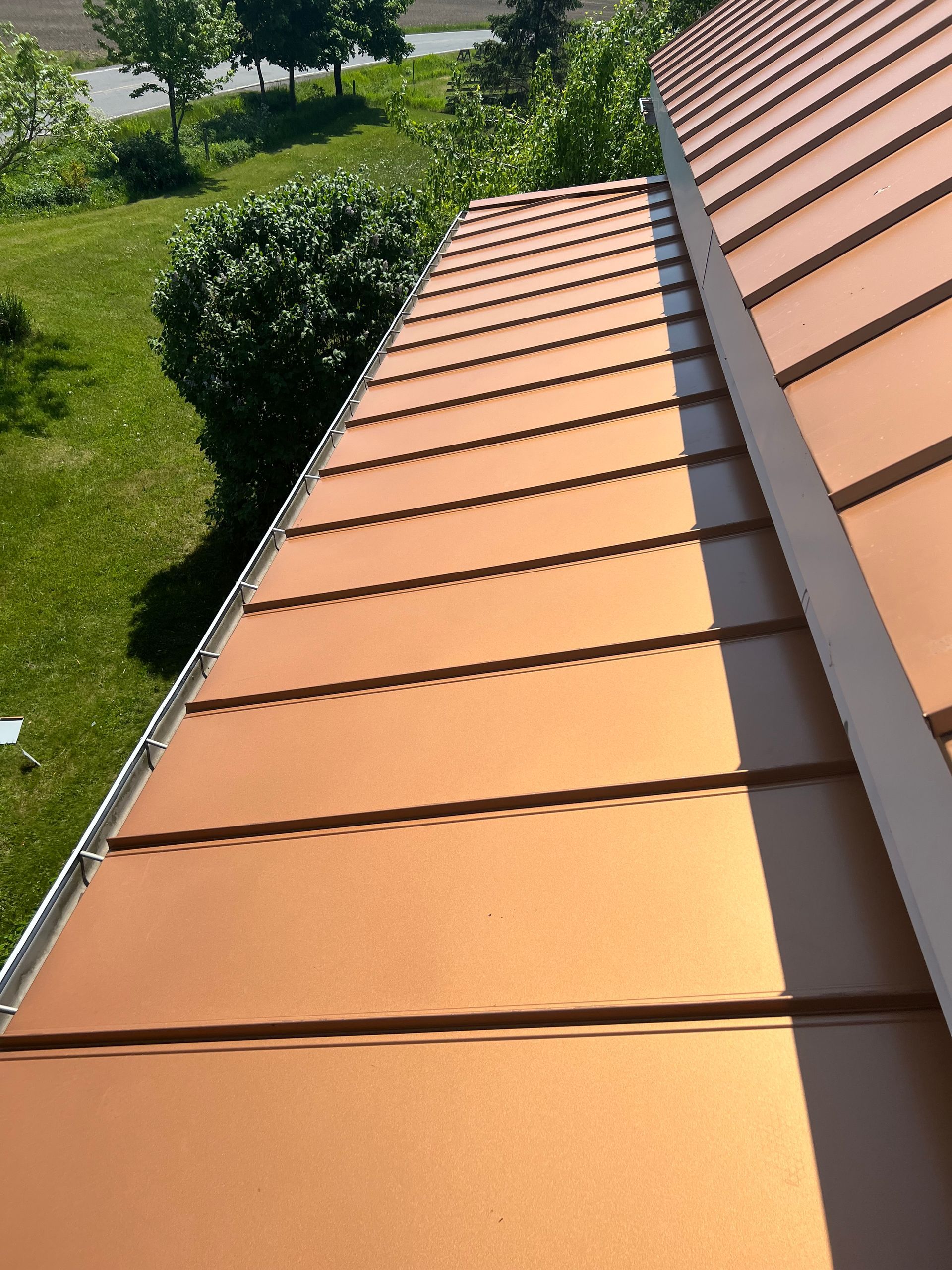 Un gros plan d'un toit en cuivre avec une gouttière blanche