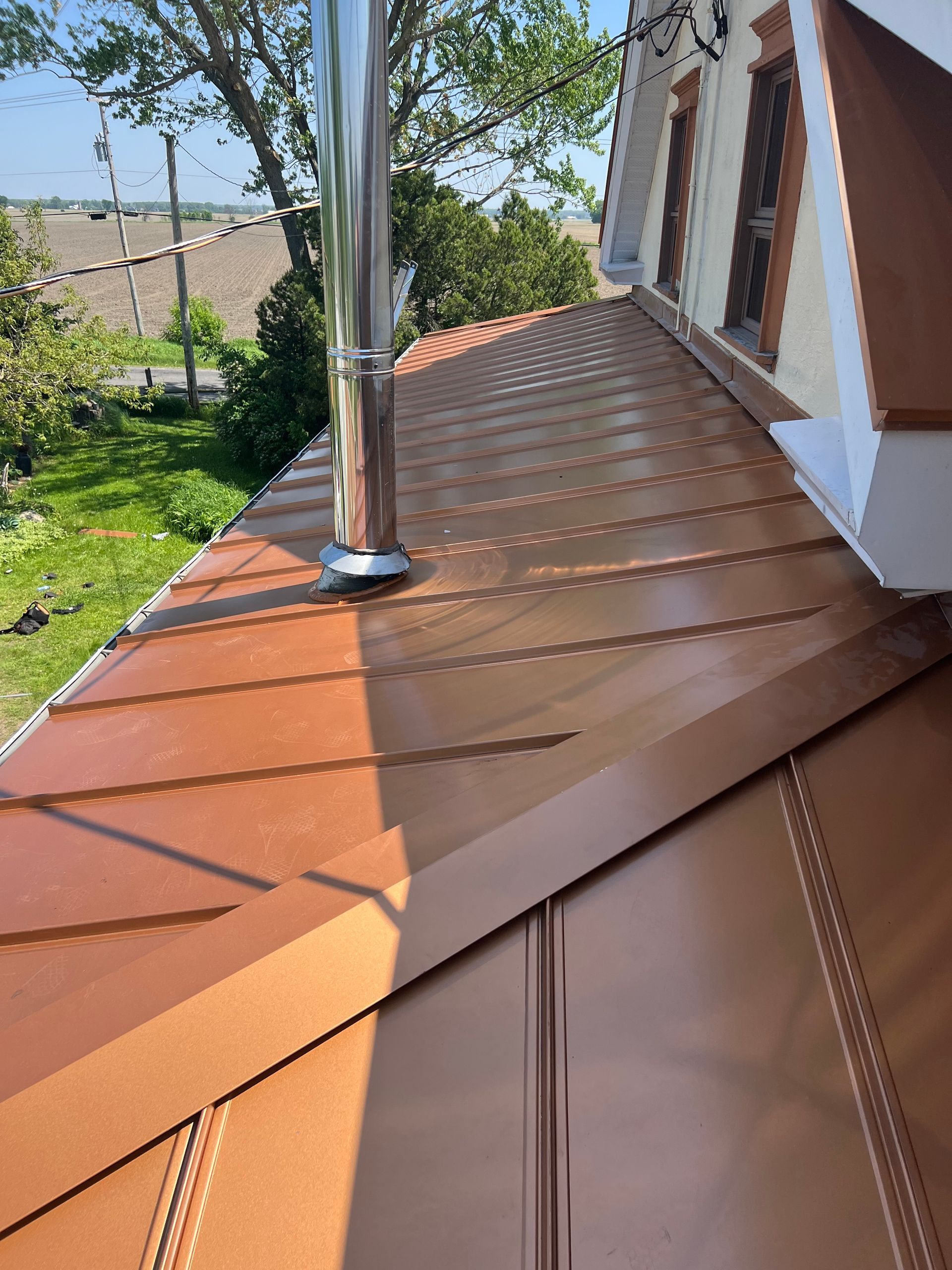 Un toit en cuivre avec une cheminée au-dessus.