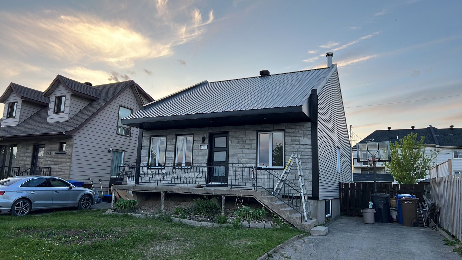Une maison avec une voiture garée devant.