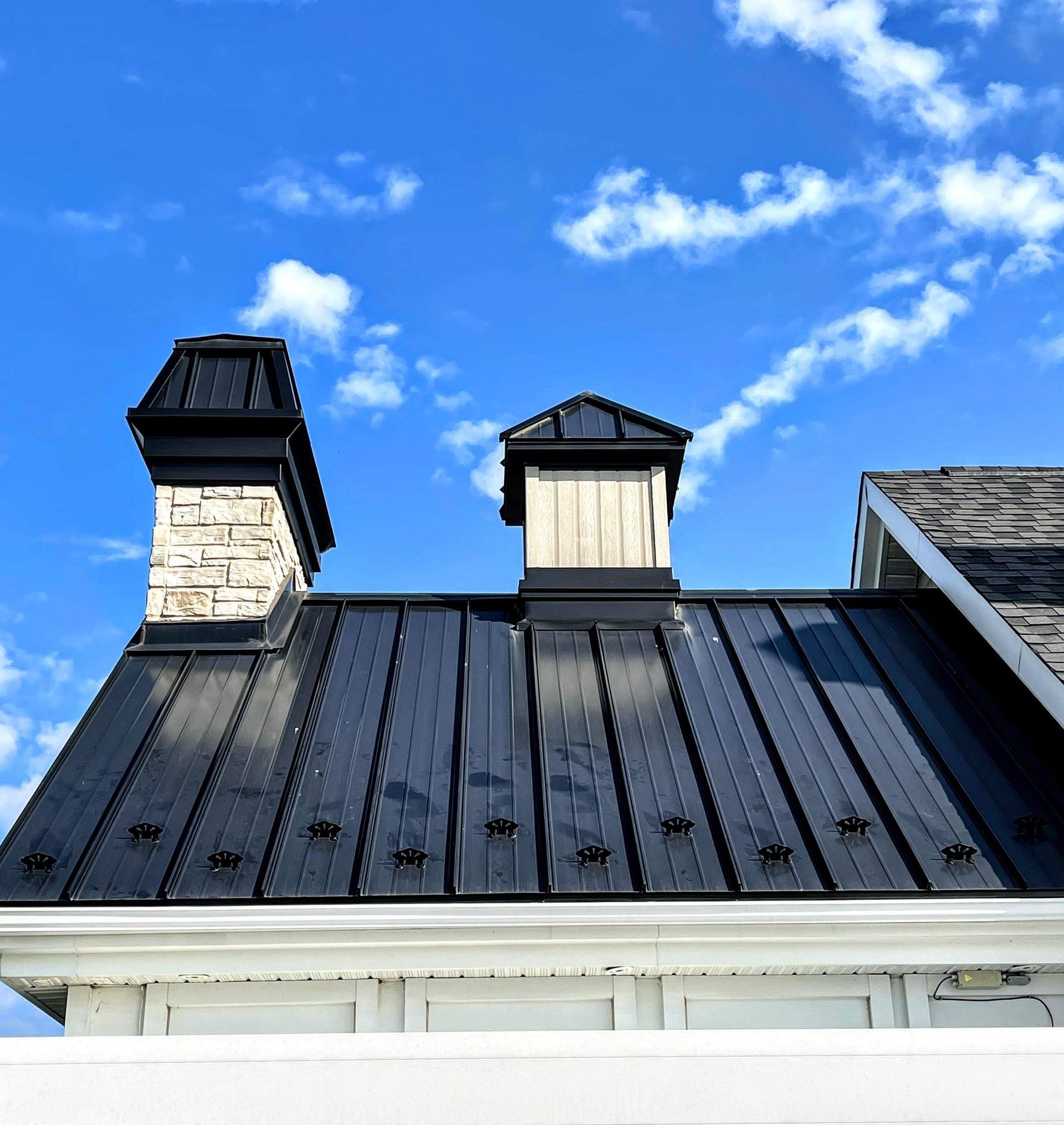 Un toit noir avec des cheminées dessus