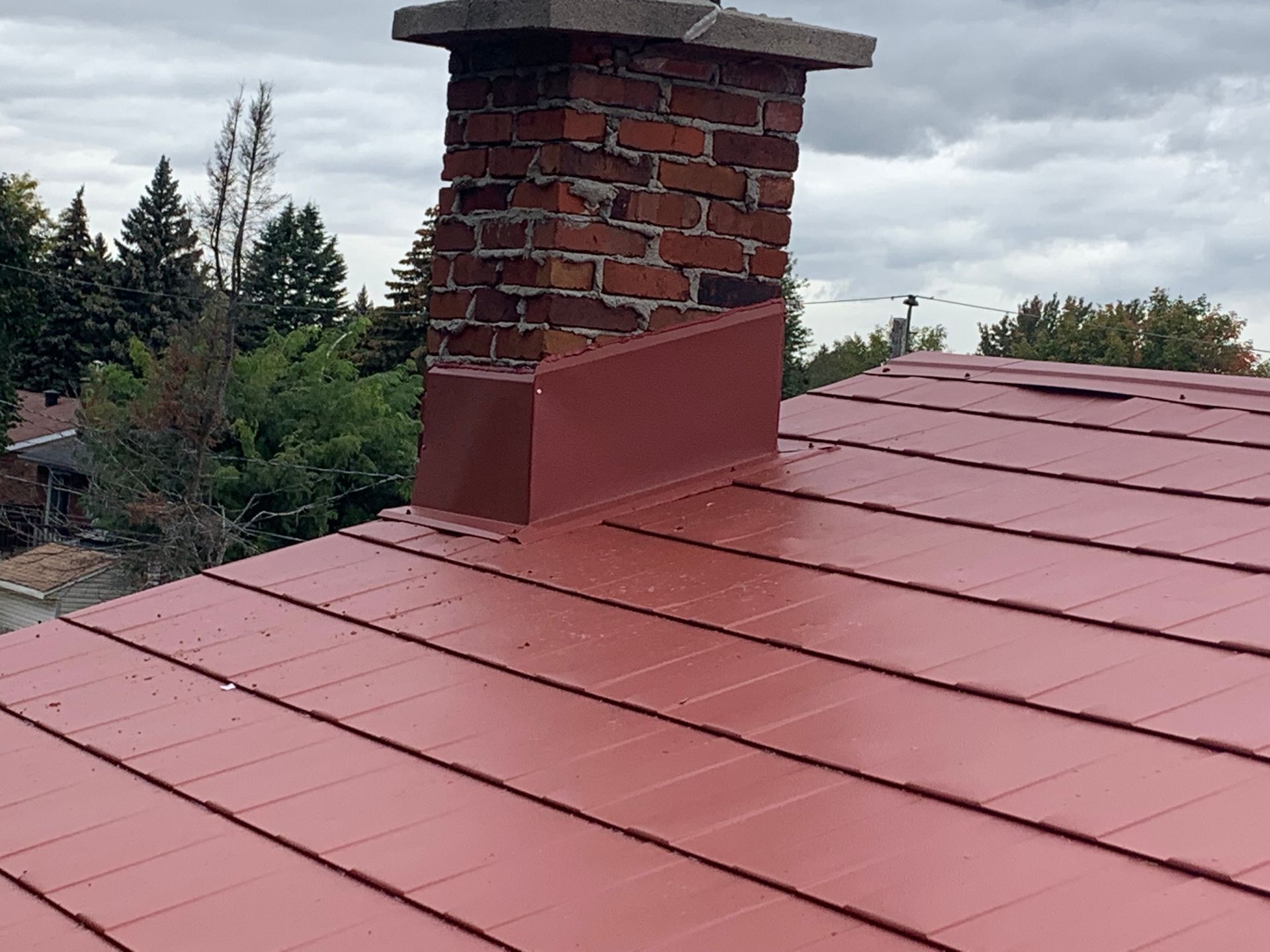Un toit rouge avec une cheminée au-dessus