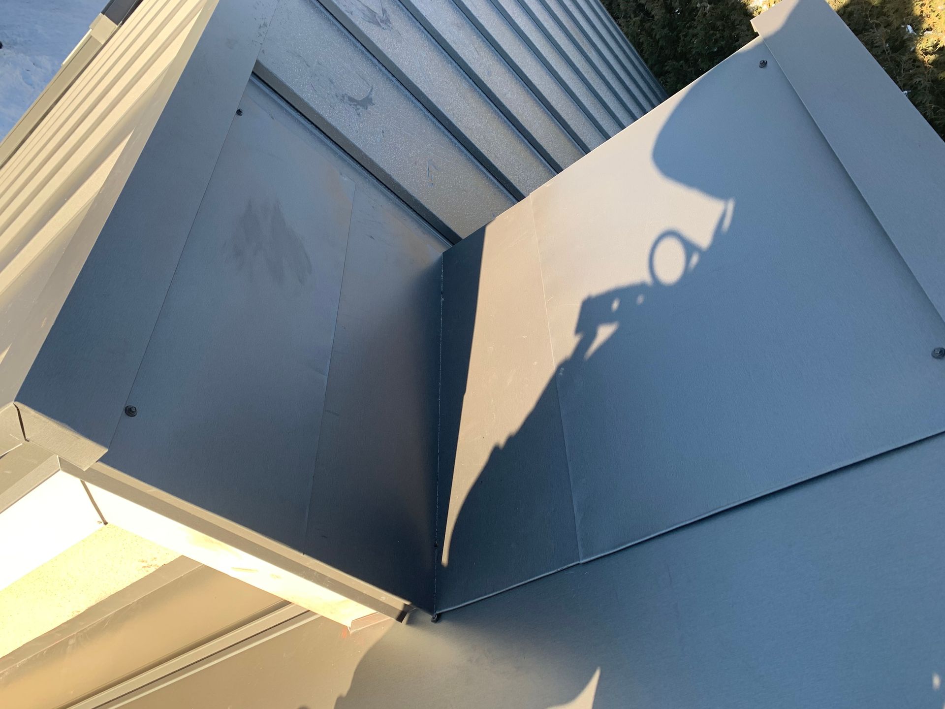 L'ombre d'une personne est projetée sur un mur bleu.