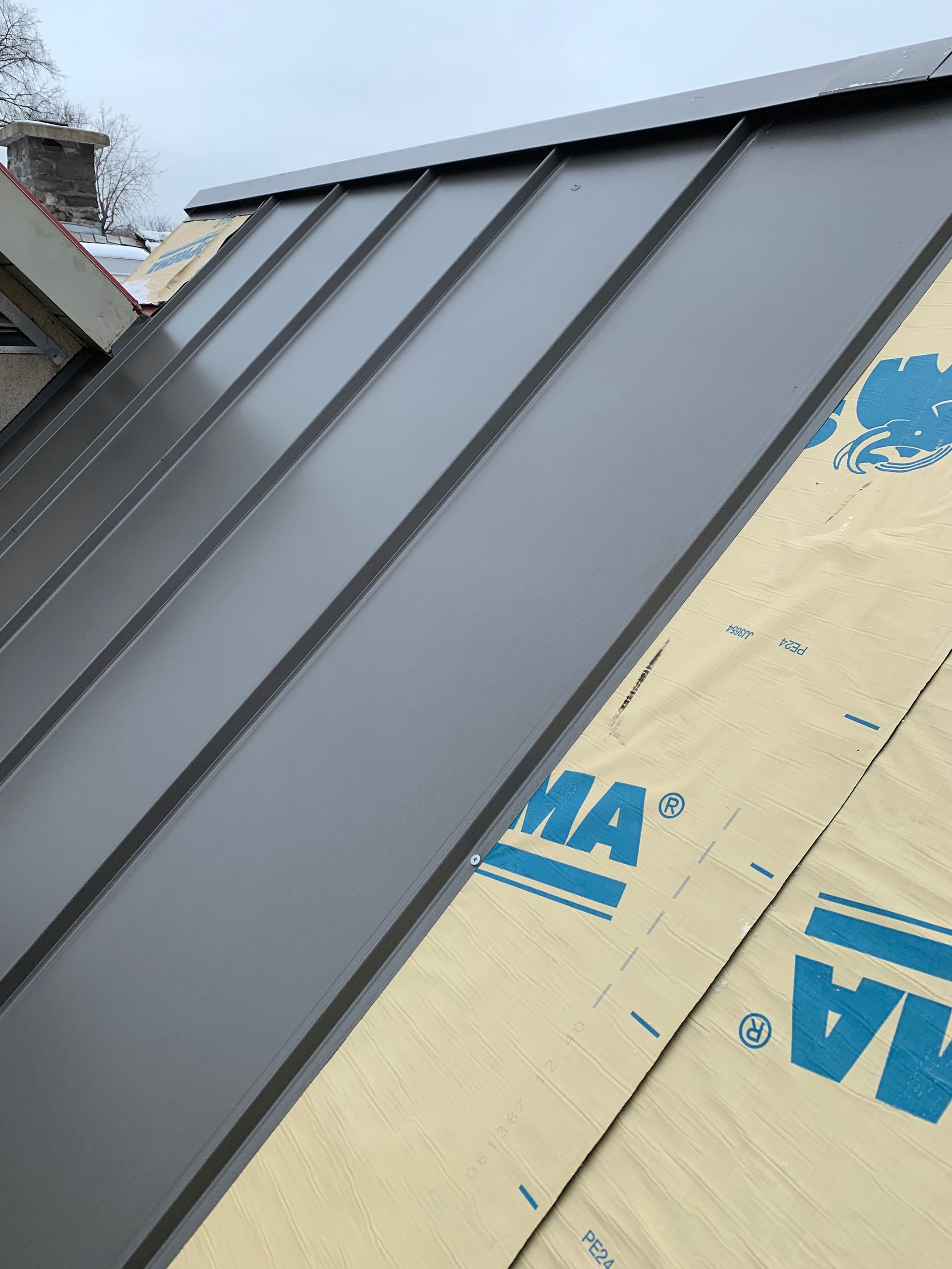 Un toit en métal est en cours d'installation sur une maison.