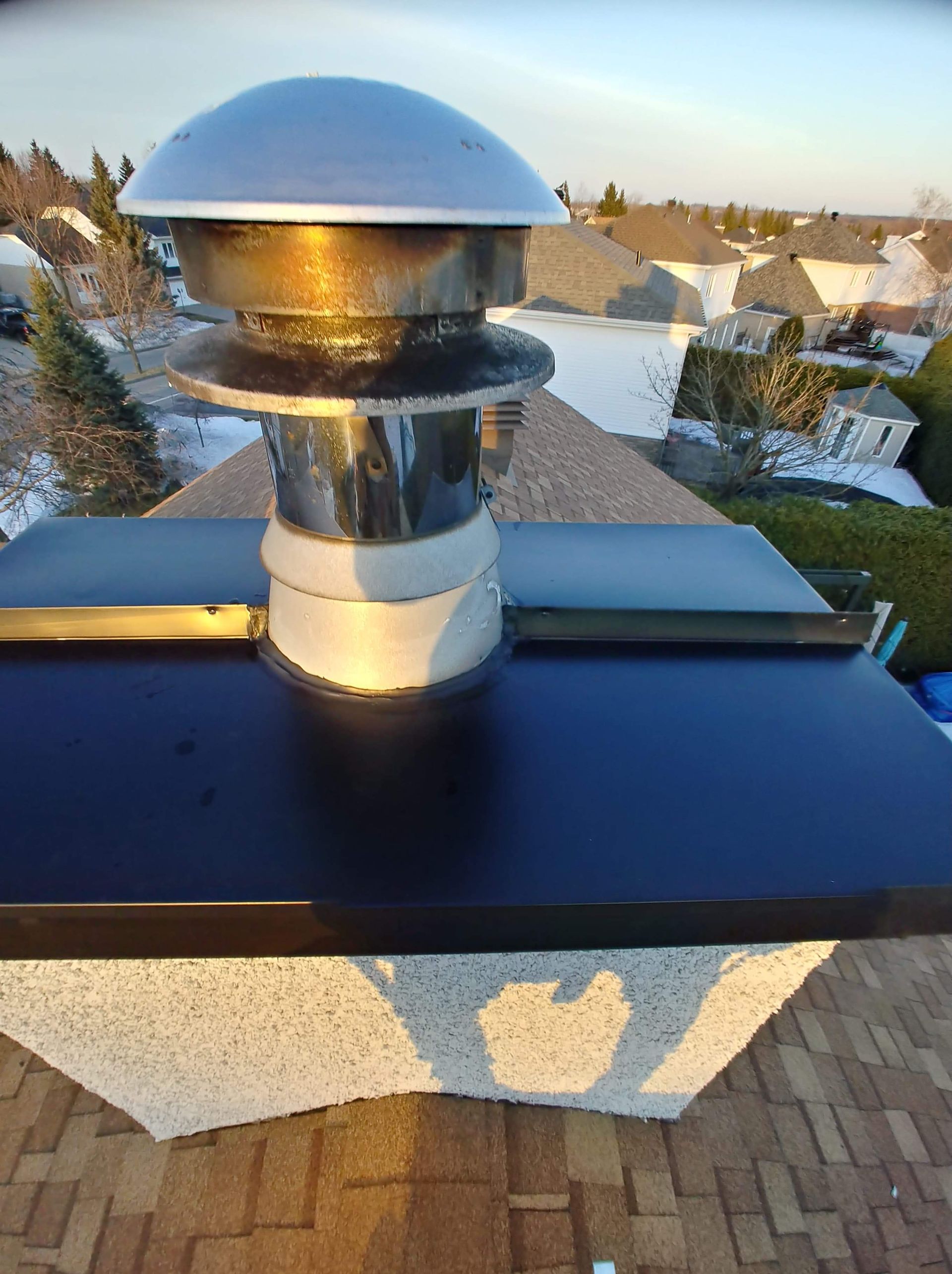 Une cheminée posée sur un toit en briques