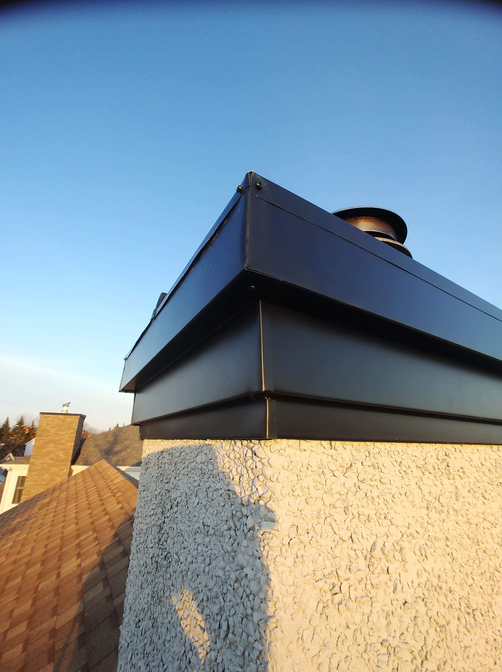 Une cheminée au sommet d'un immeuble avec un ciel bleu en arrière-plan