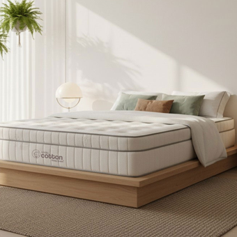 Una cama con colchón y almohadas en un dormitorio.