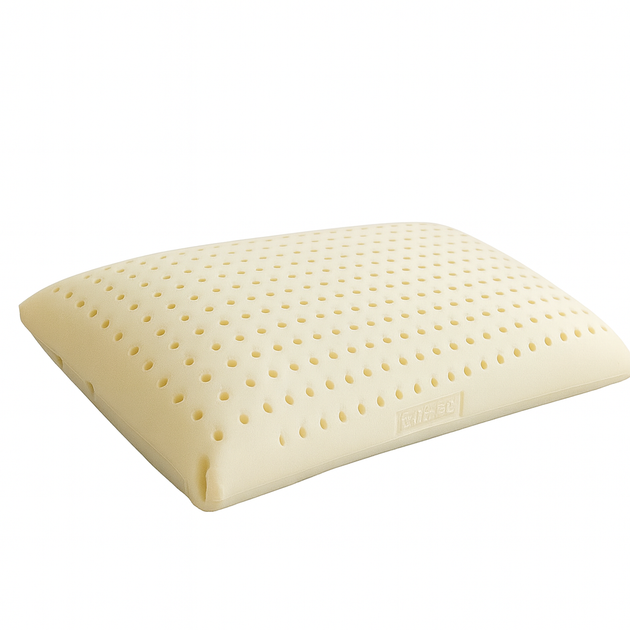 Una almohada blanca reposa sobre una superficie blanca.