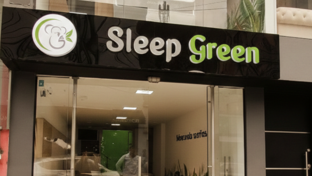 Exterior de la tienda Sleep Green con ventanas de vidrio, toldo negro y señalización verde.