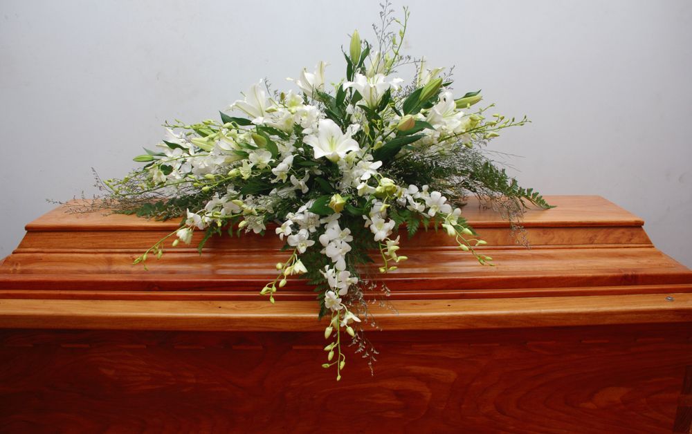 Bouquet of White Flowers on a Wooden Casket