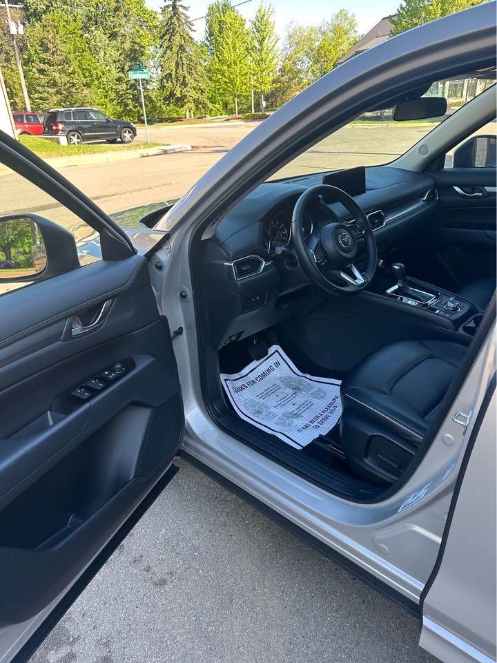 The inside of a silver car with the door open.