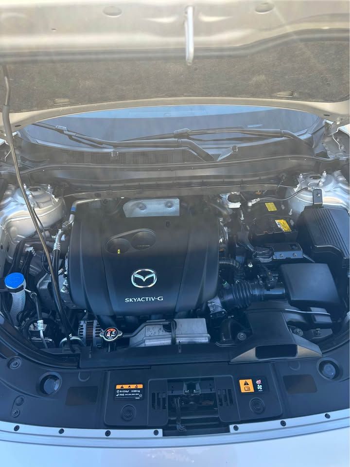 The engine of a mazda cx 5 is shown with the hood open.