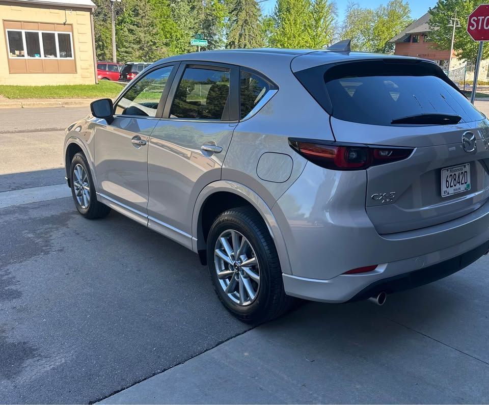 A silver car is parked in front of a stop sign
