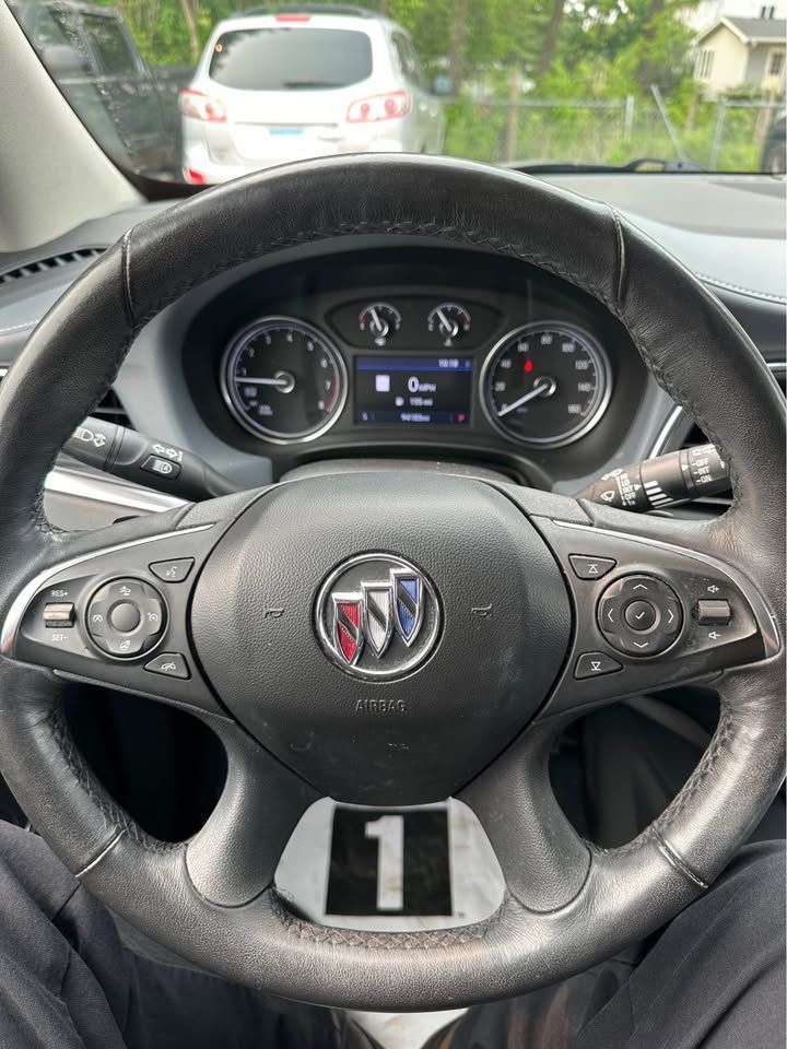 A person is sitting in a car with the number 1 on the steering wheel.