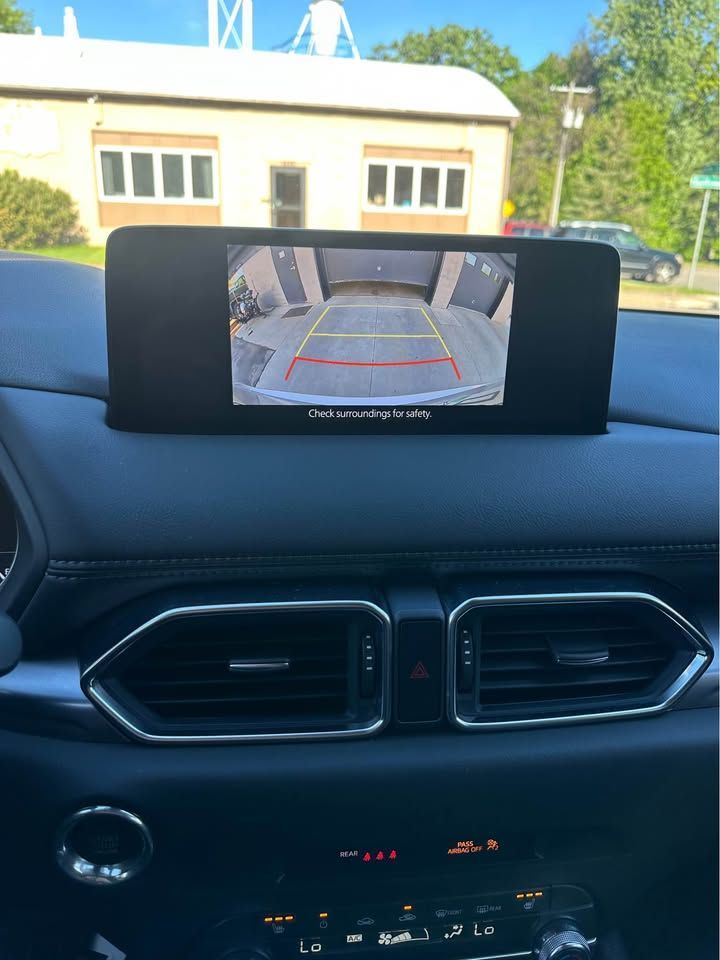A rear view camera is displayed on the dashboard of a car