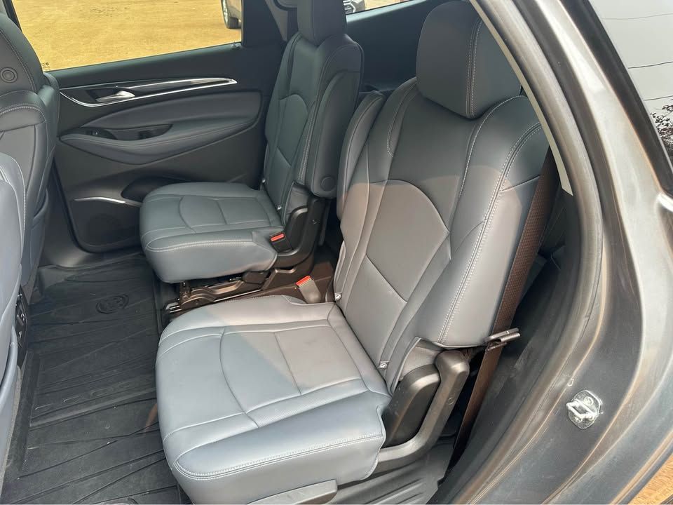 The back seat of a car with gray leather seats.