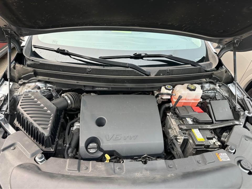 The engine of a car is shown with the hood open.