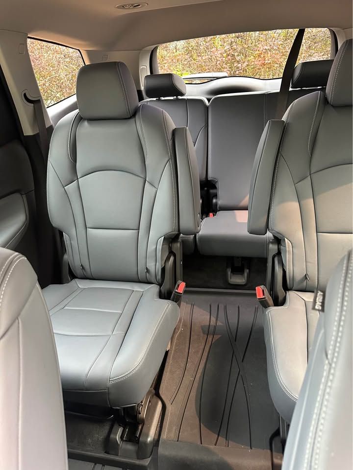The interior of a car with gray leather seats and a carpeted floor.